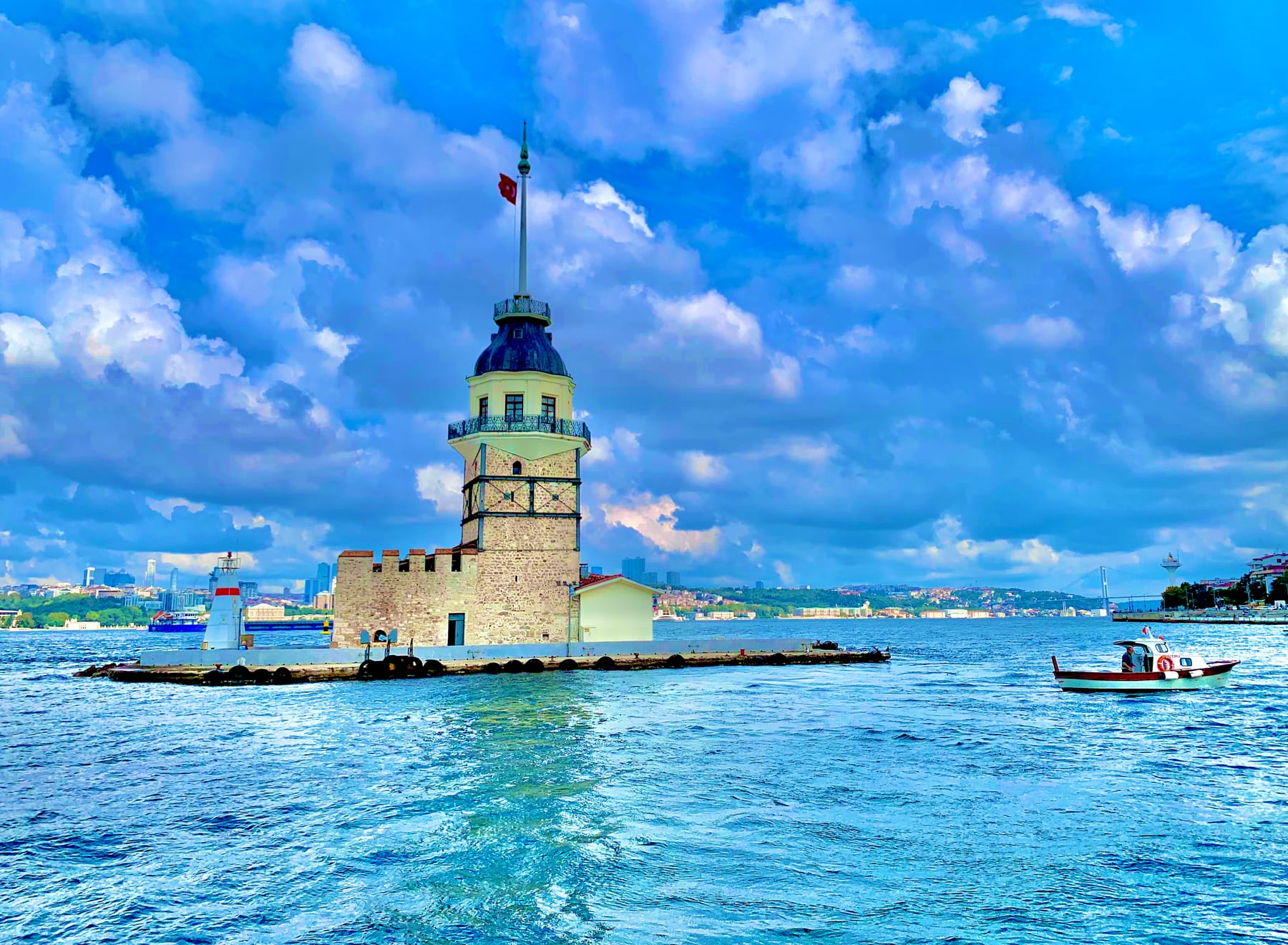 The Maiden’s Tower (Kiz Kulesi) on its islet in the Bosphorus, a small fishing boat passing on the bright blue water