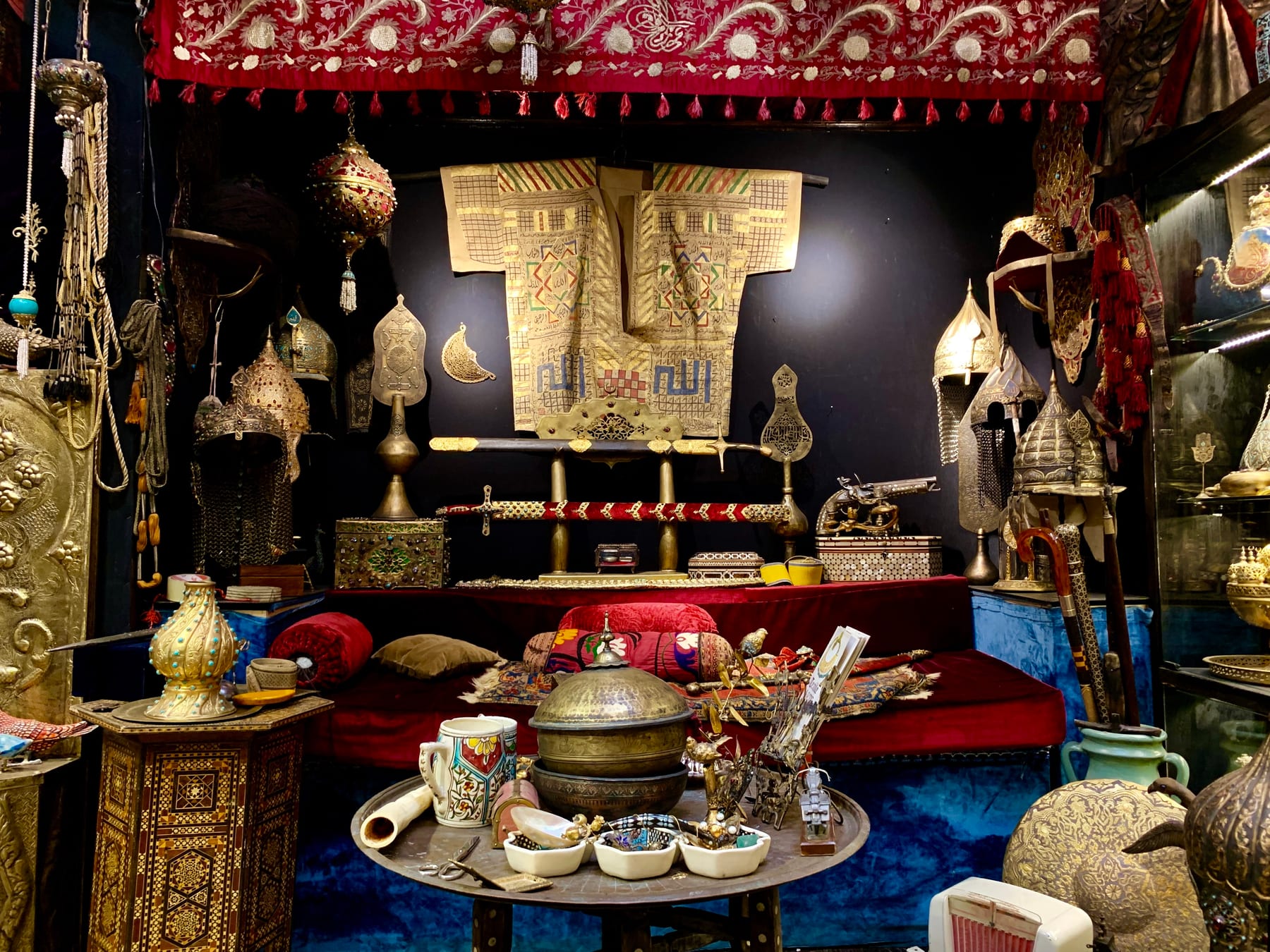 An antiques and curiosities shop in the Grand Bazaar, Istanbul, hung with lanterns, inlaid boxes, embroidered textiles and brass