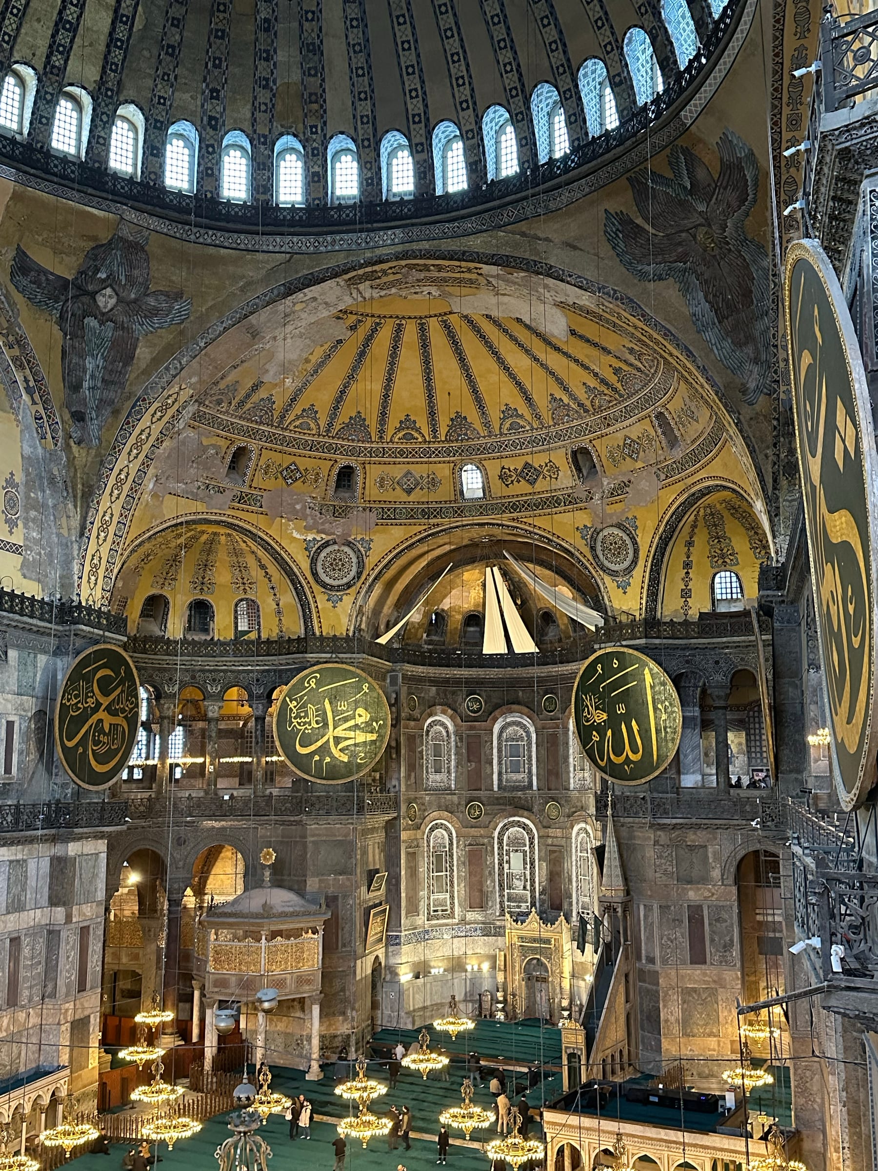 The interior of Hagia Sophia, its great dome and calligraphic medallions rising above the marble floor