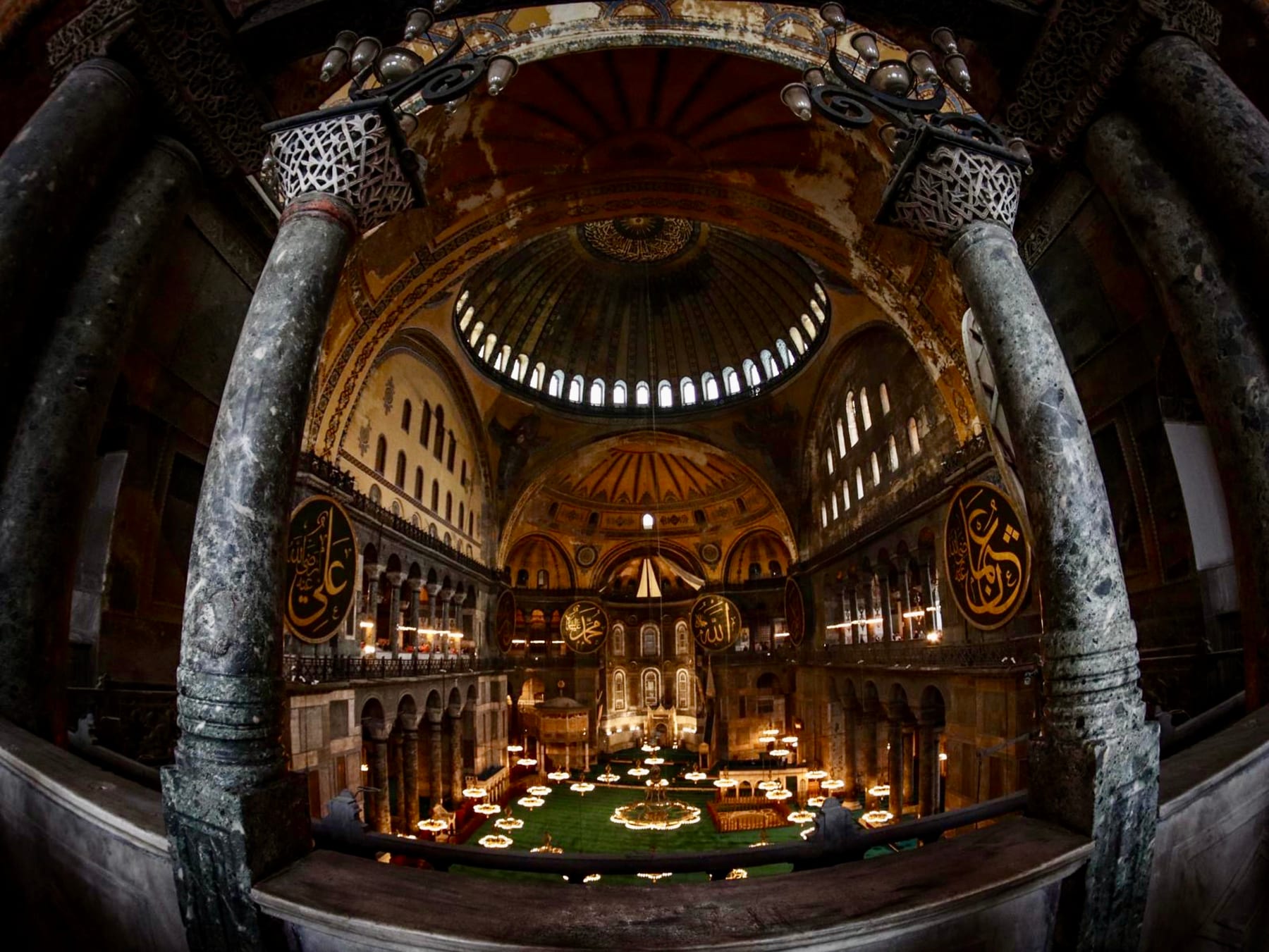 The vast domed interior of Hagia Sophia framed by marble columns in Istanbul