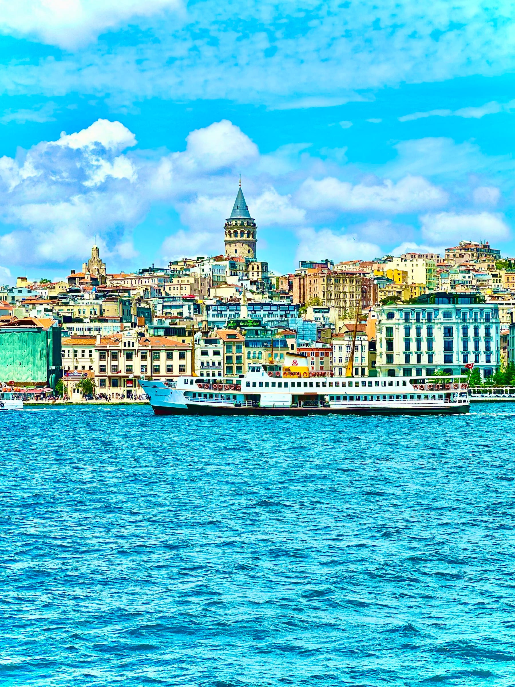 The Galata Tower above the historic Istanbul skyline with a ferry crossing the Golden Horn