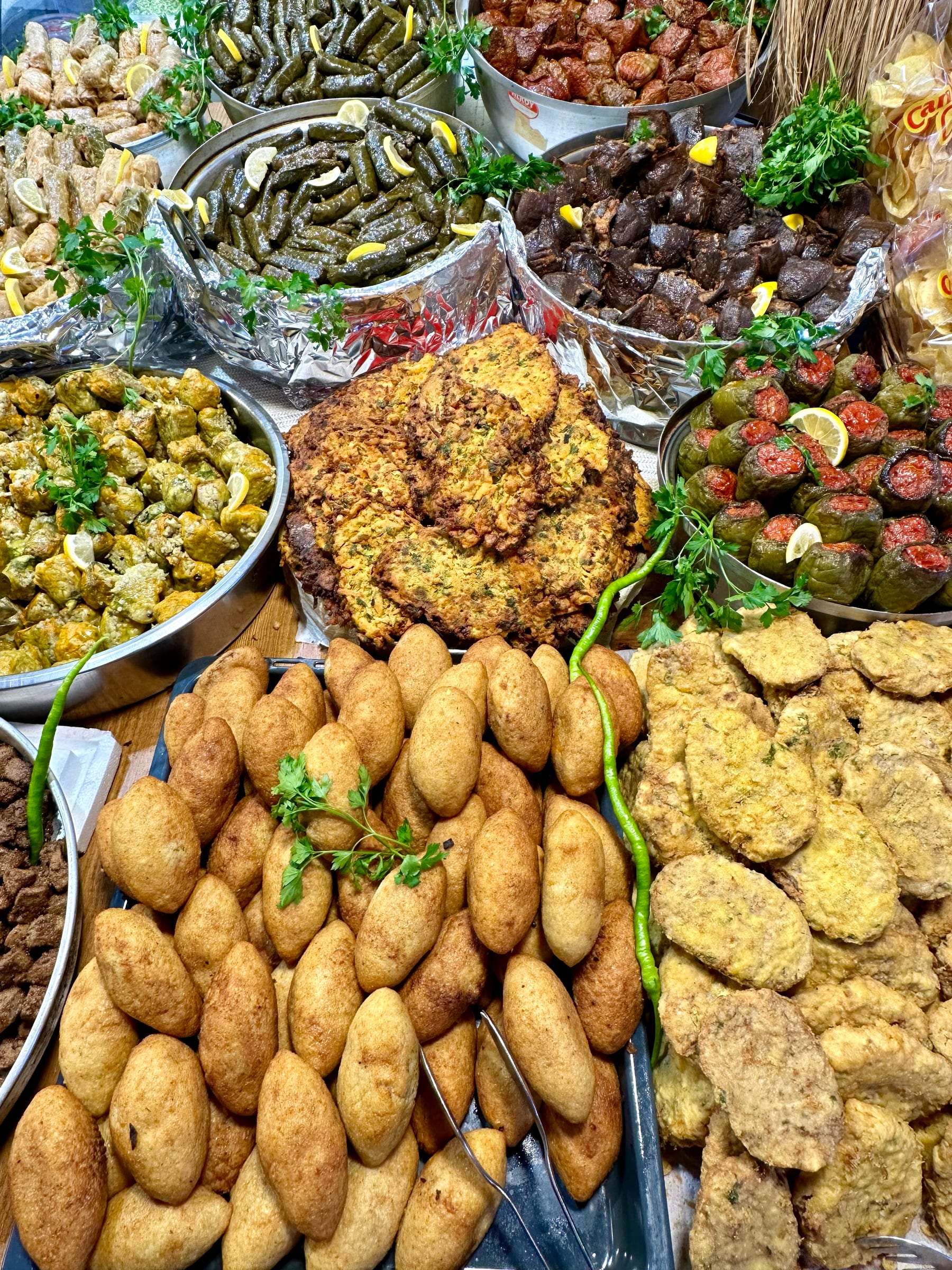 A market counter in Kadikoy piled with trays of stuffed vine leaves, fried kofte, stuffed peppers and other home-cooked Turkish dishes