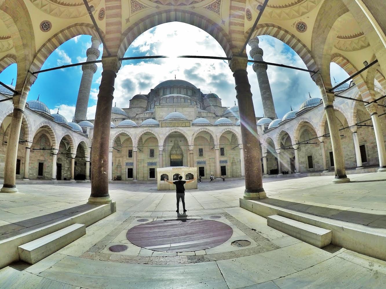 A traveller standing in the grand courtyard of the Suleymaniye Mosque